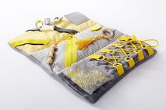 a yellow and gray bag with some items on it