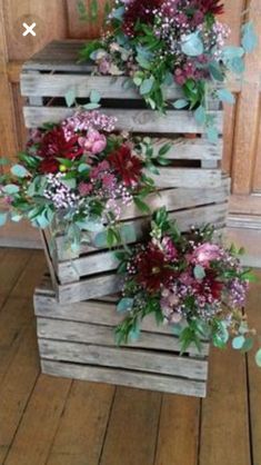 three wooden crates with flowers and greenery in them sitting on the floor next to each other