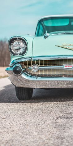 an old car is parked on the side of the road