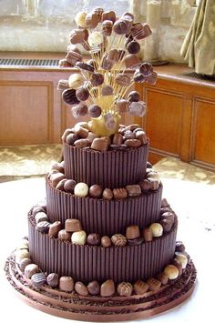 a three tiered chocolate cake sitting on top of a table