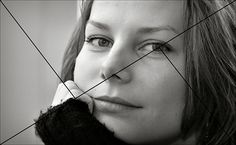 a black and white photo of a woman's face with lines in the background