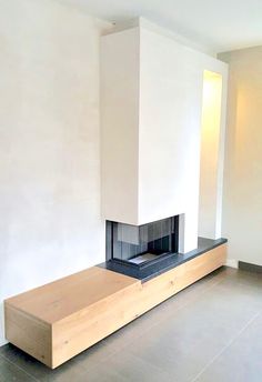 an empty room with a fireplace and white walls