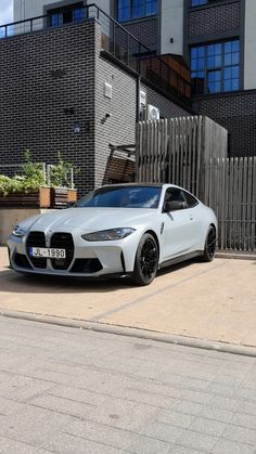 a white sports car parked in front of a building