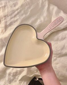 a person holding a heart shaped dish in their hand