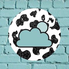 a black and white cow print cloud on a blue brick wall