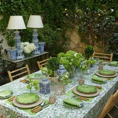 the table is set with green plates and place settings