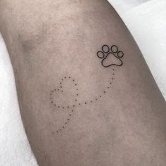 a small dog paw tattoo on the left thigh, with dots and lines drawn across it