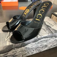 Polished Leather Slip-On Sandals In Black. Open Round Toe. Tonal Covered Stiletto Heel. Logo Plaque At Tonal Leather Sole. Gold-Tone Hardware. Approx. 3.75" Heel. Shoes Gucci, Gucci Leather, Gucci Black, Gucci Shoes, Leather Slip Ons, Stiletto Heel, Slip On Sandal, Shoes Women Heels, Stiletto Heels