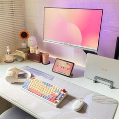 a computer desk with a keyboard, mouse and tablet on it in front of a flat screen tv