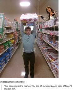 a man is holding up a bag in the middle of a grocery store aisle with shelves full of food