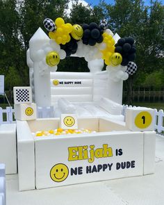 an inflatable bed is decorated with balloons and smiley faces for a birthday party