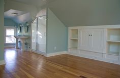 an empty living room with hard wood flooring and built - in shelving units