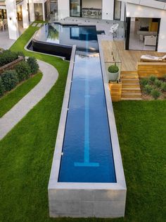 an aerial view of a modern house with a pool and decking in the yard