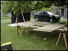 a car is parked in front of a picnic table made out of plywood planks