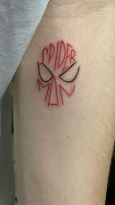 a small spider logo tattoo on the right arm and shoulder, it is red with black outline