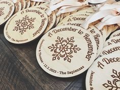 several wooden ornaments with ribbons around them on a table, one is for december and the other is for december