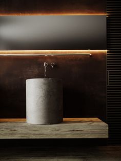 a concrete sink in front of a mirror with lights on the wall and below it