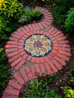 a garden path made out of red bricks with a flower design on the center and side