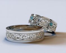 two silver wedding rings with blue topazs on each one and filigree accents