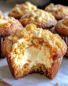 several cupcakes with white frosting and orange zest on them sitting on a table