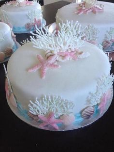 three cakes decorated with seashells and pink bows