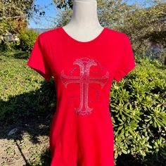 Our Royal Cross T-Shirt Is An Intricate And Dazzling Design. The Cross Is Made With 5 Rhinestone Sizes And Intricate Detail That Gives It A Greater Sparkle Than Any Other T-Shirt. Can Be Perfect For Layering And An Absolute Must-Have Wardrobe Basic. Want To Make All The Women Jealous? Purchase This One-Of-A-Kind T-Shirt! Sizes: Small: Chest Width 27", Shirt Length 23", Sleeve Length 4", Sleeve Width 10" Medium: Chest Width 30", Shirt Length 24", Sleeve Length 4.5", Sleeve Width 11" Large: Chest Fitted Silver T-shirt With Short Sleeves, 40 Shirt, Rhinestone Cross, Small Chest, The Cross, Must Haves, Layering, Sparkle, Womens Tops