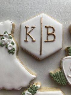 decorated cookies are arranged in the shape of wedding gowns and monogrammed cookies