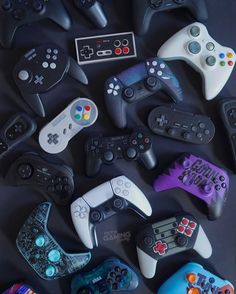 many different video game controllers on a black surface