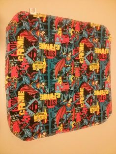 an old comic book cover is hanging on the wall above a toilet paper roll that's covered in comics