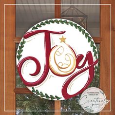 a christmas ornament hanging on the side of a door with a joy sign