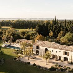 an aerial view of a large house in the middle of a field with trees around it