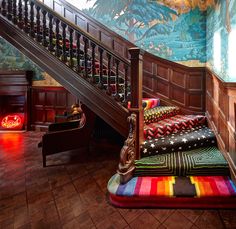 a stair case next to a set of stairs in a room with colorful rugs on the floor