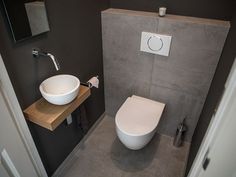 a white toilet sitting next to a sink in a bathroom