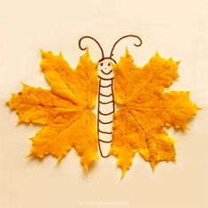 a yellow leaf with a drawing of a caterpillar on it's side