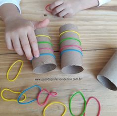 a child is playing with some toilet paper and scissors on the wooden table next to them