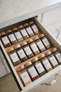 an open drawer filled with lots of different types of spices on top of a counter