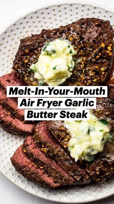 two steaks are on a plate with butter and seasoning sprinkled on them