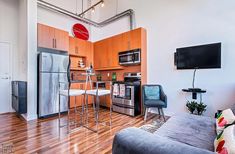 a living room filled with furniture and a flat screen tv mounted to the side of a wall