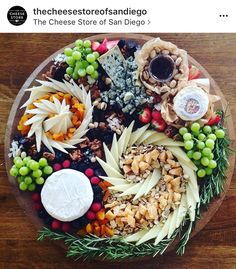 a platter with grapes, nuts and cheese