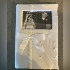 a wedding photo frame with a white ribbon on it