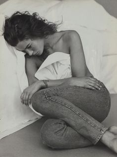 a black and white photo of a woman sitting on the floor