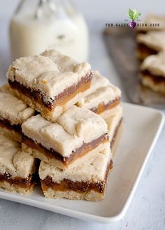 a white plate topped with cookies and marshmallows next to a glass of milk