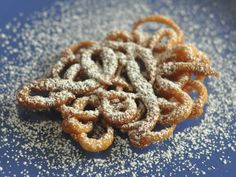 powdered sugar coated pretzels on a blue plate