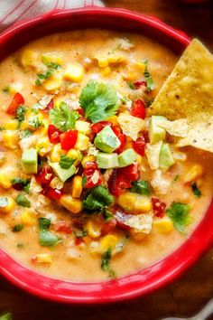 a red bowl filled with corn, salsa and tortilla chips