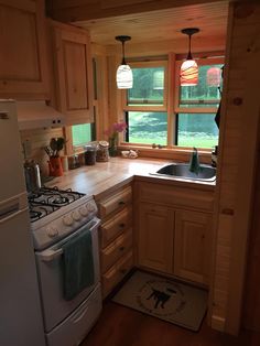 a kitchen with a stove top oven next to a sink and refrigerator freezer combo