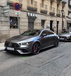 two cars parked in front of a building on the side of a street next to another car