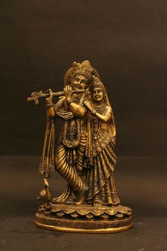 an antique brass figurine with a flute in its hand and a bird on the arm