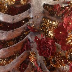 red flowers and gold leaves on the trunk of a tree