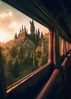 a train with hogwarts castle seen through the window