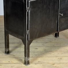 a metal cabinet sitting on top of a wooden floor